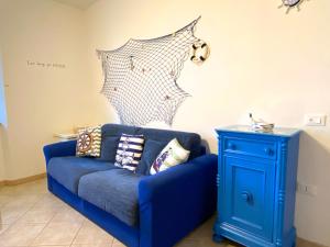 un sofá azul con almohadas junto a una mesa en Appartamento Bucaniere en San Vincenzo