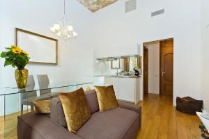 un soggiorno con divano e tavolo in vetro di Boutique Apartment Elegantissima a Torino