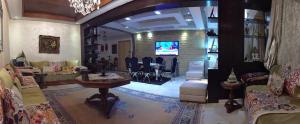 Il comprend un salon doté d'un canapé et d'une télévision. dans l'établissement Adam's home, à Rabat