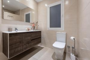 a bathroom with a toilet and a sink and a mirror at Chalet Tiro del Pichón I in Marbella