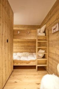 a room with three bunk beds with white sheets at Magnifique appartement dans luxueux chalet - ARAVIS in Crest-Voland