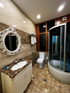 La salle de bains est pourvue d'un lavabo, de toilettes et d'un miroir. dans l'établissement Prestige Prime Hotel, à Baku