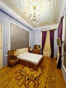 a bedroom with a bed and a chandelier at Prestige Prime Hotel in Baku