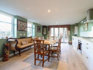 a kitchen and dining room with a table and a couch at The Gate House in Colchester