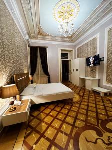 a bedroom with a bed and a table and a chandelier at Prestige Prime Hotel in Baku