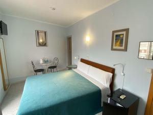 a hotel room with a bed and a table and chairs at Hotel Alexandra Sitges in Sitges