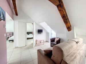 a living room with a couch and a bedroom at Au Fil De L'eau - Le Jerzual in Dinan