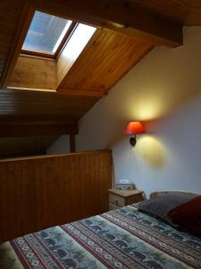 a bedroom with a bed with a wooden headboard and a window at Le Rustica, 3 rooms, 3 stars, 6 people in Les Houches