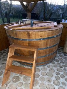 a wooden wine barrel with a wooden stool at Pensiunea Ramona in Viscri