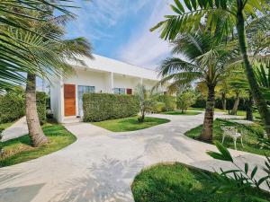 a driveway with palm trees in front of a house at MEET Boutique Resort in Surat Thani