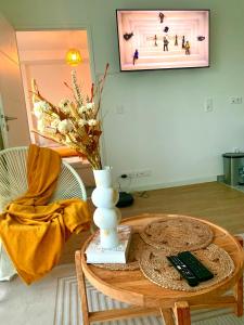 - un salon avec une table et un vase dans l'établissement Le Bali Cosy House - T2 lumineux et moderne en plein centre ville de Maisons-Alfort, à Maisons-Alfort