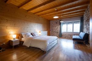 een slaapkamer met een bed en een houten muur bij La Ferme du Bonheur - Un cocon d'authenticité au cœur de la nature in Cruseilles