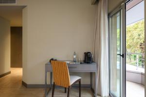 a desk with a chair in a room with a window at Melia Setubal in Setúbal