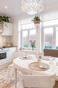 a kitchen with a table with chairs and a chandelier at Rüütli 24-2 in Pärnu