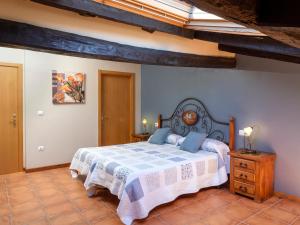 ein Schlafzimmer mit einem Bett mit einer blauen und weißen Decke in der Unterkunft Casa rural ALBIRENA in Arraiz-Orquín