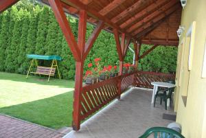 a wooden pergola with a table and chairs on a patio at NAPSUGAR VEND&Eacute;GH&Aacute;Z in Bog&aacute;cs