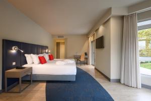 a hotel room with a bed and a large window at Melia Setubal in Setúbal