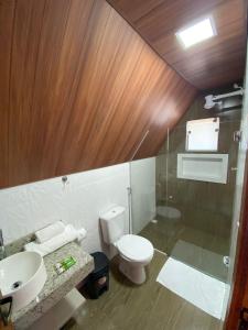 a bathroom with a toilet and a sink and a shower at Chalezinho Pousada in Brumadinho
