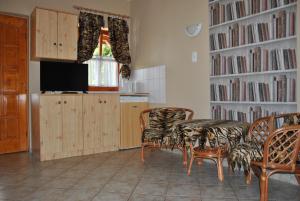 a living room with a table and chairs and a tv at NAPSUGAR VENDÉGHÁZ in Bogács