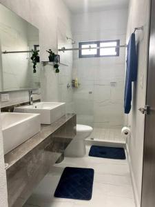 Casa con alberca en Residencial Portovela في نويفو فايارتا: حمام أبيض مع حوض ومرحاض