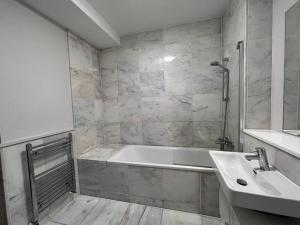 La salle de bains est pourvue d'une baignoire et d'un lavabo. dans l'établissement Modern flat near Oxford Street, à Londres