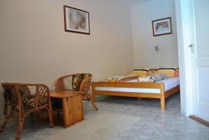 um quarto com uma cama, uma mesa e cadeiras em NAPSUGAR VENDÉGHÁZ em Bogács