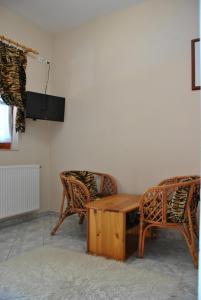 uma sala de estar com 2 cadeiras e uma mesa de madeira em NAPSUGAR VENDÉGHÁZ em Bogács