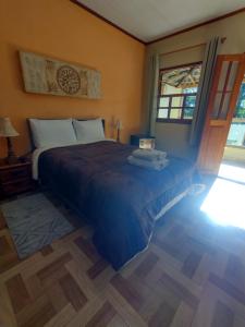 een slaapkamer met een bed in een kamer met een raam bij Chalés de Santana in Tiradentes