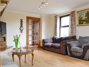 a living room with two couches and a table at Three Views Bungalow in Talgarth
