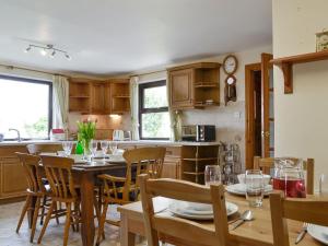 a kitchen and dining room with a table and chairs at Three Views Bungalow in Talgarth