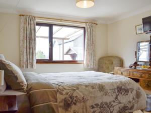 a bedroom with a large bed and a window at Three Views Bungalow in Talgarth
