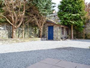 a stone house with a blue door in a yard at Three Views Bungalow in Talgarth