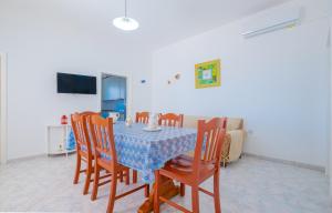 comedor con mesa, sillas y TV en Villetta Maredorat Vista Mare by HDSalento, en Torre Vado