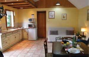 a kitchen and living room with a table and a couch at Gites Des Blanchiries in Aubin-Saint-Vaast