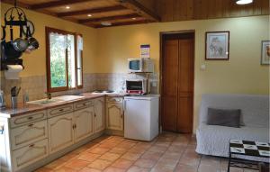 La cuisine est équipée d'un réfrigérateur blanc et d'un four micro-ondes. dans l'établissement Gites Des Blanchiries, à Aubin-Saint-Vaast