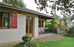 une maison avec une porte rouge et une terrasse dans l'établissement Gites Des Blanchiries, à Aubin-Saint-Vaast
