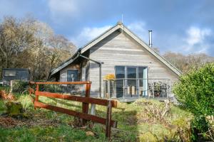 una casa vieja con una valla delante de ella en Harbour Master en Kilmelfort