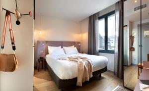 a hotel room with a bed and a large window at Hébé Hotel in Annecy