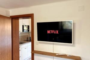 una TV a schermo piatto a parete in cucina di Wohnung mit Balkon in Velden - Appartment BERGE byTILLY a Velden am Wörthersee
