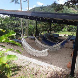 a hammock swing in a park with trees in the background at Finca Pozo Azul in La Vega