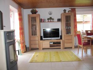 ein Wohnzimmer mit einem Flachbild-TV und einem Tisch in der Unterkunft Ferienhaus Gretel  in Greetsiel
