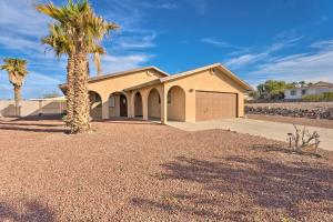 a house with a palm tree and a garage at Bullhead City Home Less Than 2 Mi to Colorado River! in Bullhead City