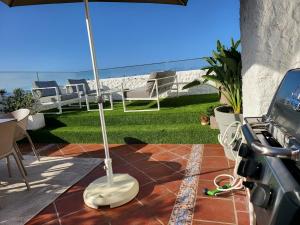 a patio with an umbrella and a table and chairs at Infinity View in Puerto de la Cruz