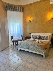 1 dormitorio con 1 cama y 1 mesa con sillas en Hotel Lungomare, en Reggio Calabria