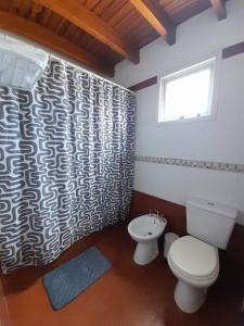 uma casa de banho com um WC e uma cortina de chuveiro em Duplex equipado para 4 personas. em Godoy Cruz
