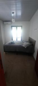 1 dormitorio con 1 cama en una habitación con ventana en Casa FLORIANÓPOLIS, Praia de PONTA DAS CANAS,1, en Florianópolis