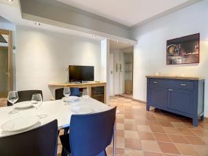 - une salle à manger avec une table, des chaises et une télévision dans l'établissement Residence il Pino, à Marina di Castagneto Carducci