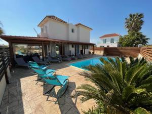 un patio con tumbonas y una piscina en Tarracotta Villa 4 bedroom, near Ayia Napa, en Ayia Napa