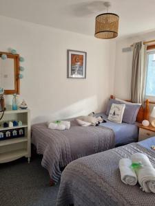 a bedroom with two beds with stuffed animals on them at Bungalow 62,North Cornwall, St. Tudy in Saint Tudy