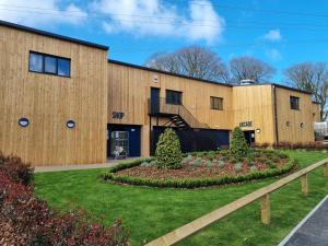 un bâtiment avec un jardin en face dans l'établissement Bungalow 62,North Cornwall, St. Tudy, à Saint Tudy